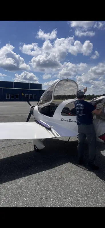 Joseph Joe Helminiak working beside a light-sport aircraft canopy